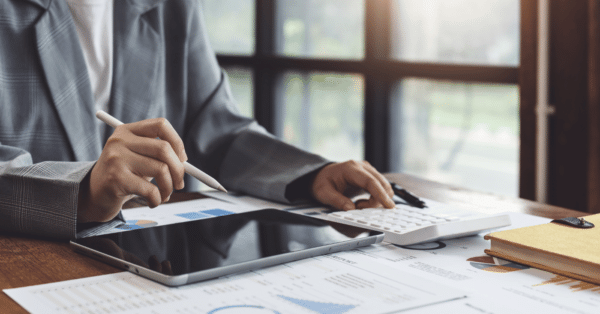 performing accounting at desk with tablet and tools