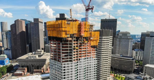 crane construction on skyscraper amid city landscape