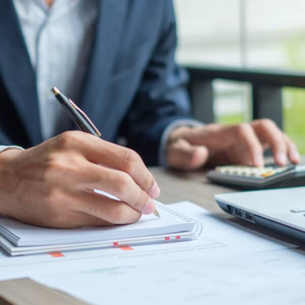 accountant working on laptop and paper with pen
