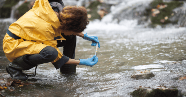woman test water in river