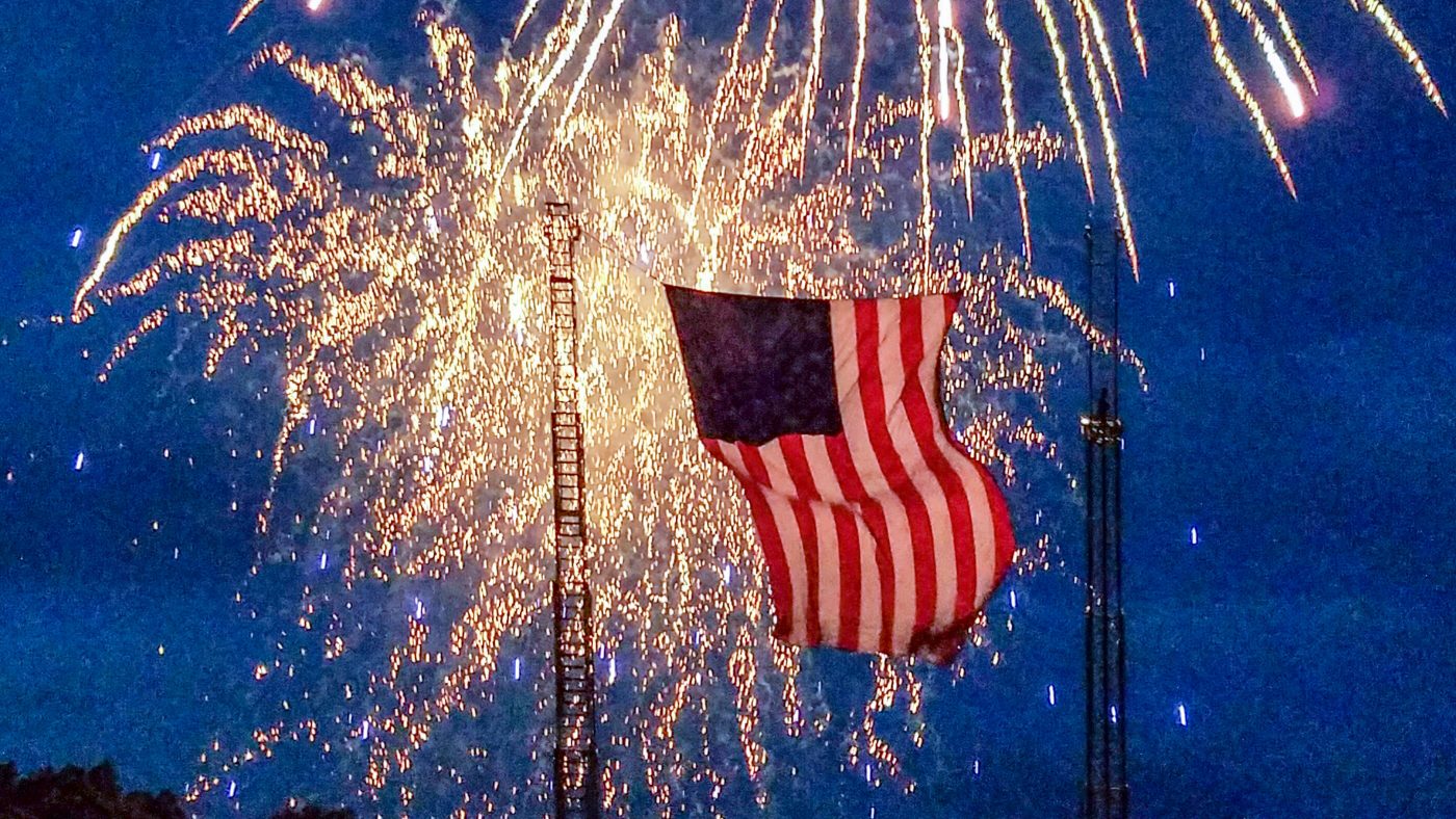 american flag in front of fireworks 4th of july